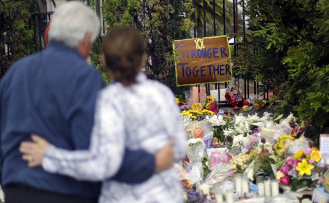 A couple embrace near a growing memorial across the street from the Chabad of Poway synagogue in Poway, Calif., on April 29, 2019. A gunman opened fire, killing one person, on April 27, 2019, as about 100 people were worshipping. The attack happened exactly six months after a mass shooting in a Pittsburgh synagogue.