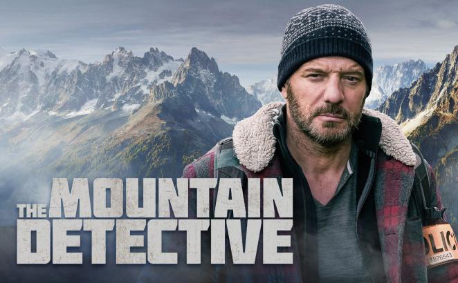 Mountain Detective  Detective in the foreground mountains in the background with show title.