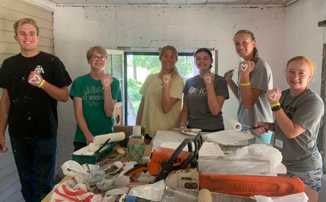 SERVE participants from Twin Cities SERVE paint the entryway to a farmhouse at a local organic farm in July 2022.