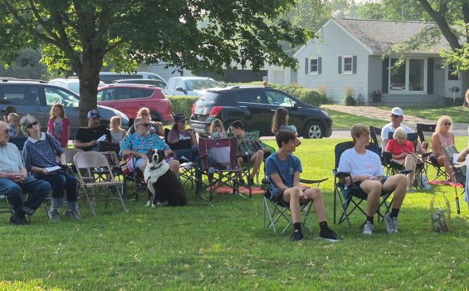 Parishioners of Rolling Acres CRC, some with their dogs, gather on the neighborhood church’s property for the “Dog Days of Summer” service.