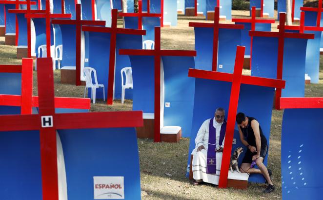 Carlos Felice, a 37-year-old Venezuelan living in Panama for five years, right, confesses to local Catholic priest Gabriel Agustin Guardia in an outdoor confessional, after exercising with his dog at Omar Park in Panama City on Jan. 23, 2019, ahead of a visit by Pope Francis. 
