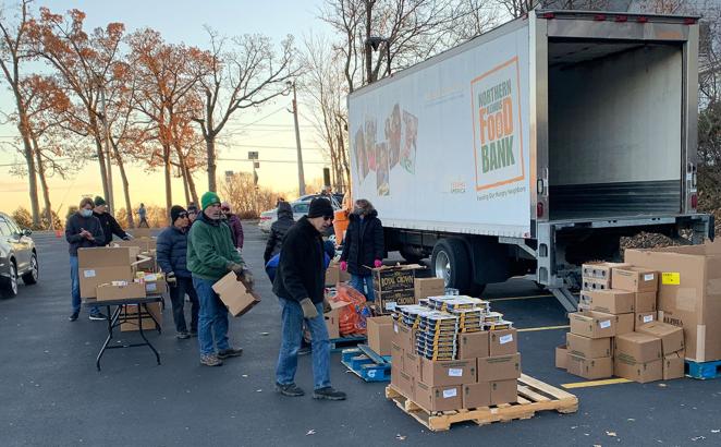 Volunteers unload a Northern Illinois Food Bank truck for distribution in a parking lot of St. Anne’s Episcopal Church in Woodstock, Ill., Nov. 22, 2021.
