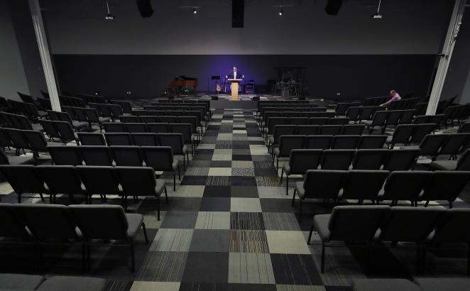 In this March 22, 2020, file photo, Josh Kellso, a pastor at Grace Bible Church, delivers a sermon via livestream from an empty sanctuary in Tempe, Arizona. (AP Photo/Matt York)