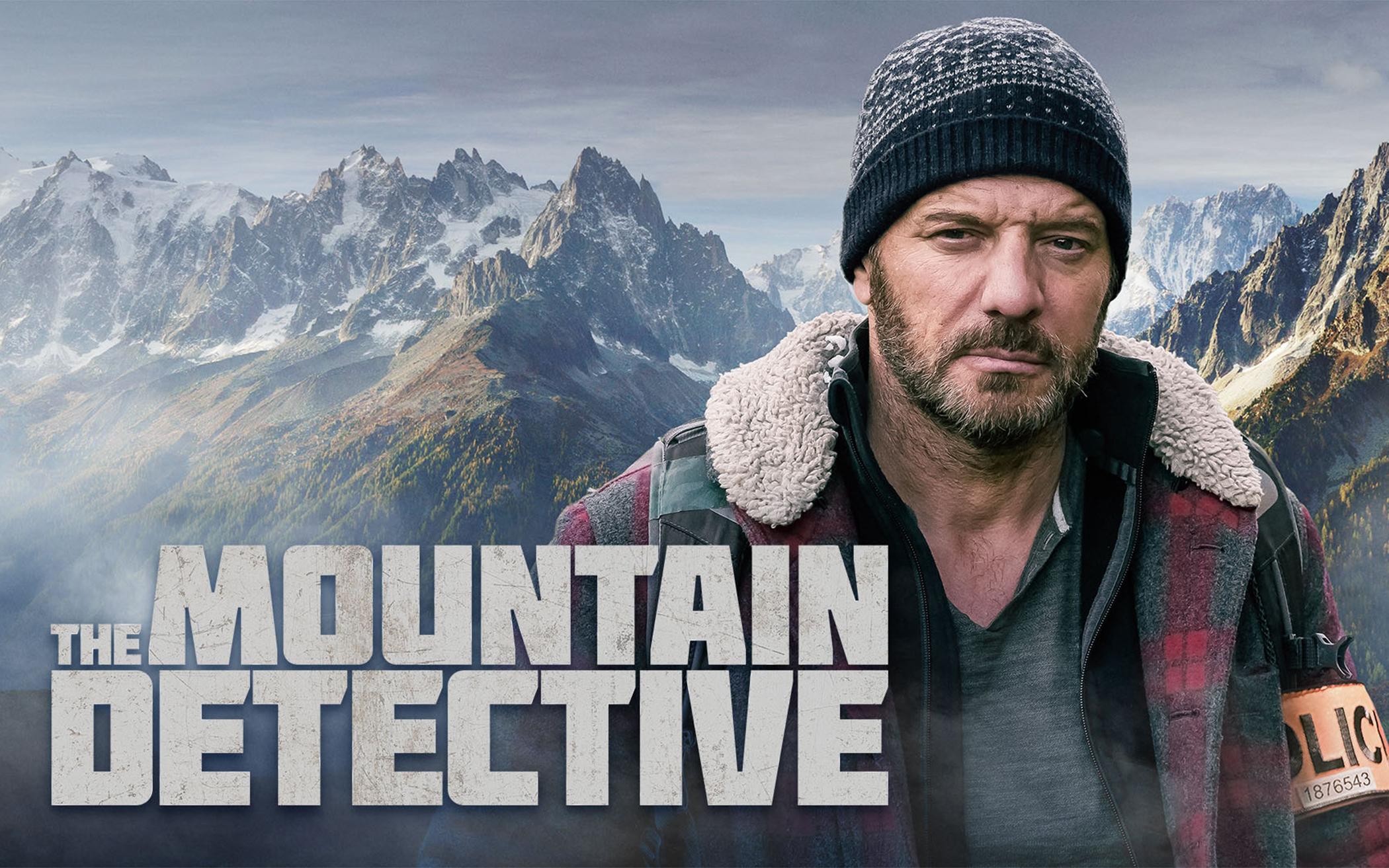 Mountain Detective  Detective in the foreground mountains in the background with show title.