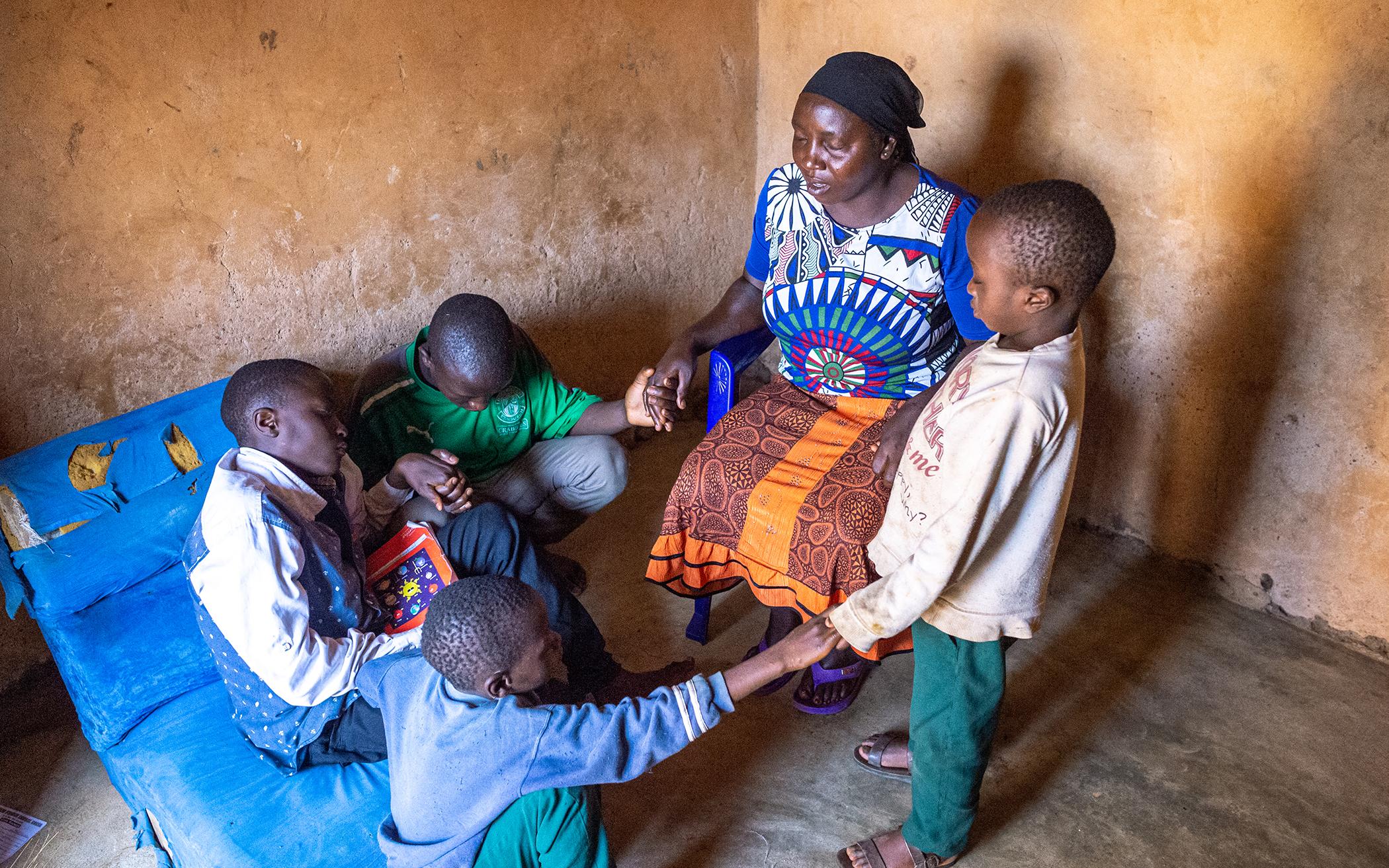 Nvou prays with her sons Wisdom, Godfrey, Reuben, and John
