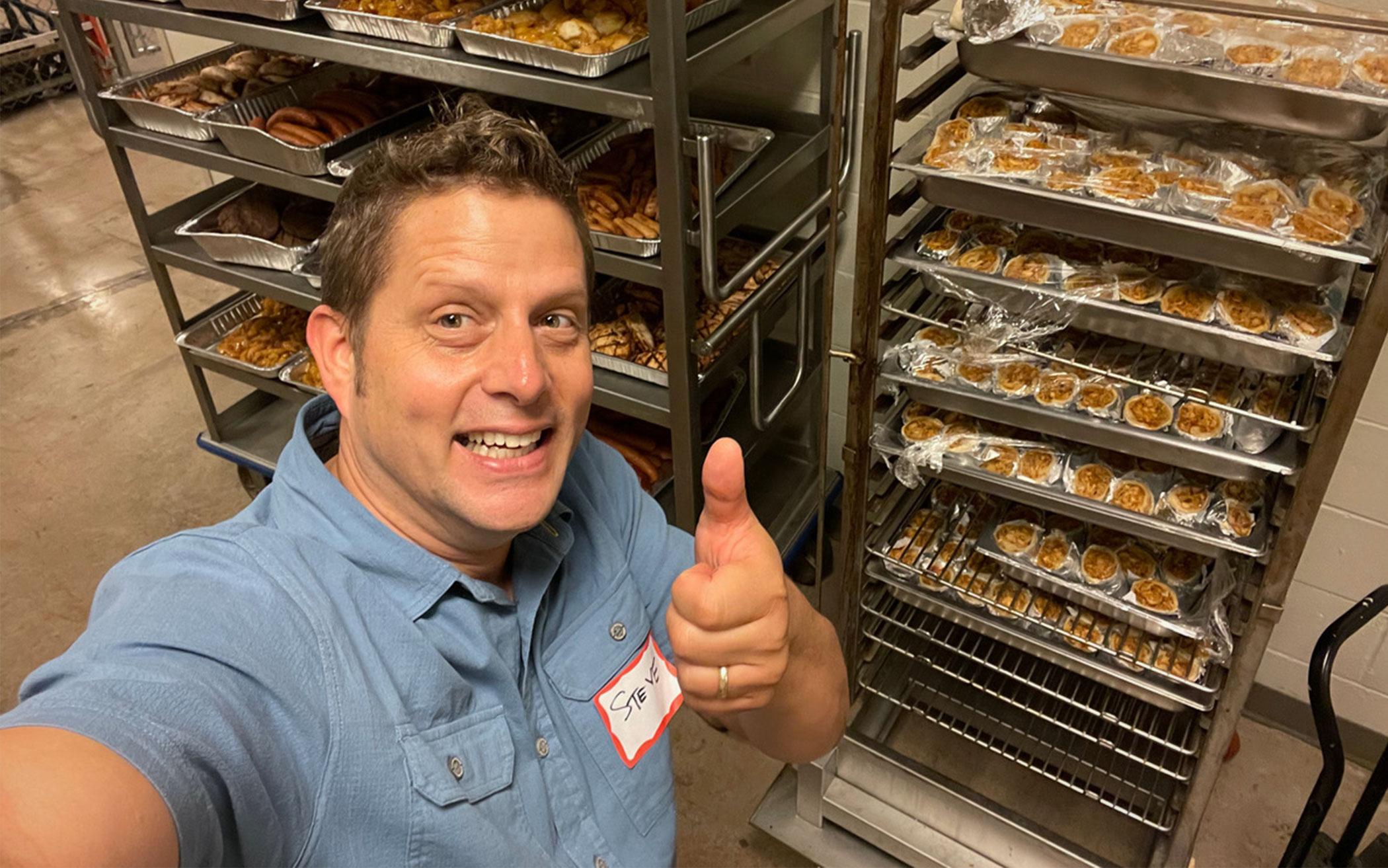 man standing in front of racks of baked goods
