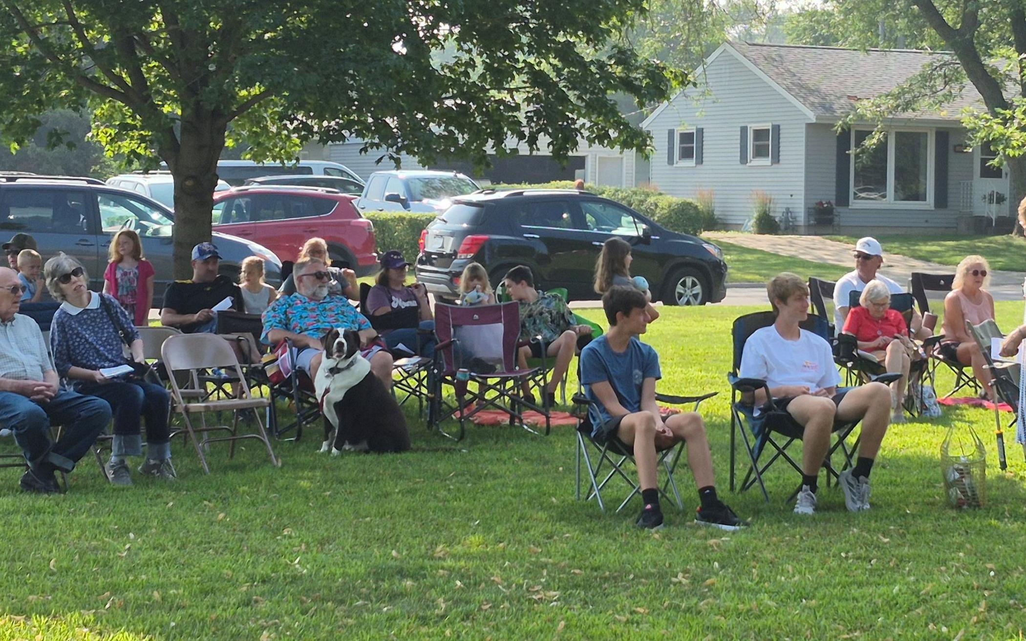 Parishioners of Rolling Acres CRC, some with their dogs, gather on the neighborhood church’s property for the “Dog Days of Summer” service.