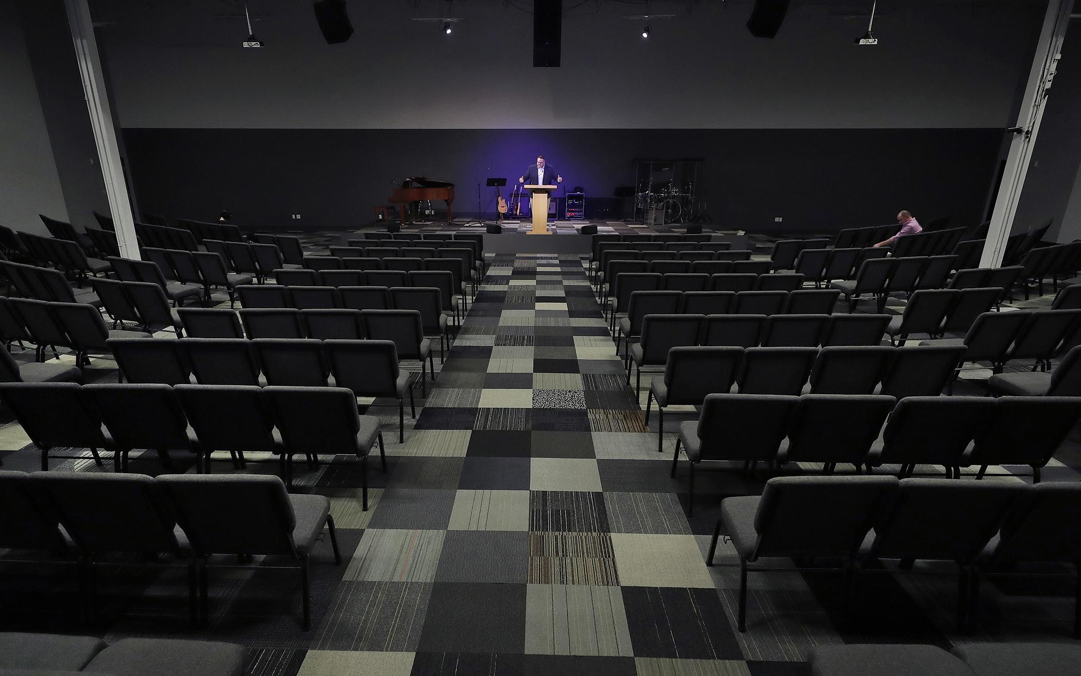 In this March 22, 2020, file photo, Josh Kellso, a pastor at Grace Bible Church, delivers a sermon via livestream from an empty sanctuary in Tempe, Arizona. (AP Photo/Matt York)